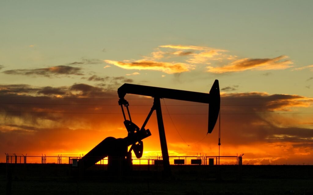 Oil pump jack on an oil field at sunset